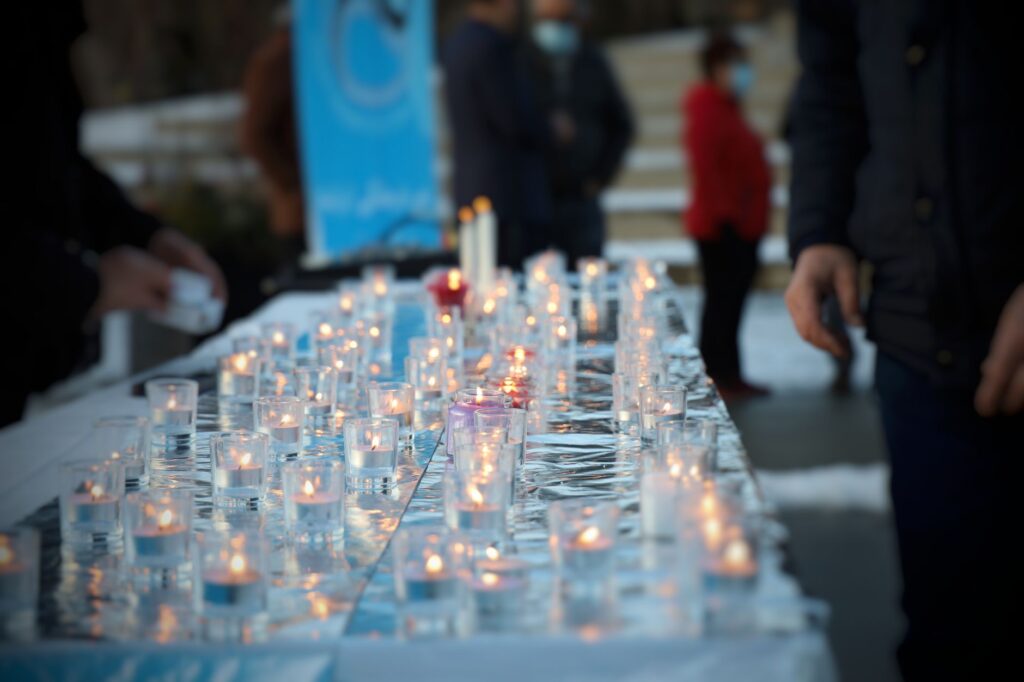 community members gathering at a vigil following a fatal shooting
