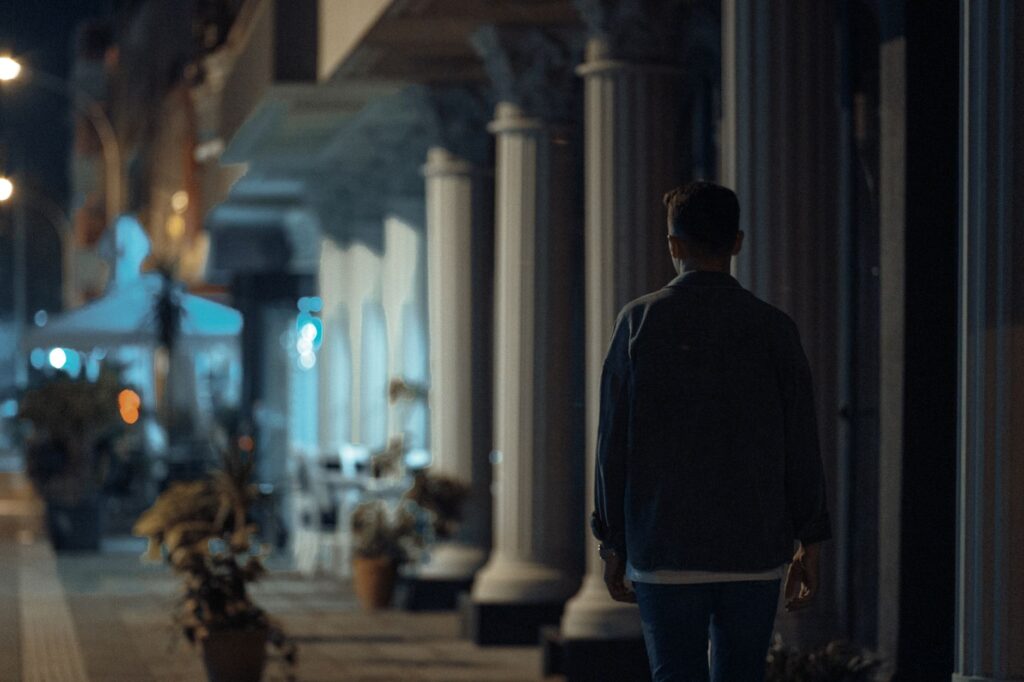 person walking safely through a well-lit Los Angeles street at night