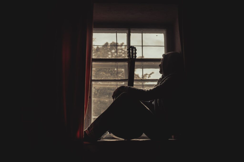 isolated person by window reflecting mental health struggles in Washington