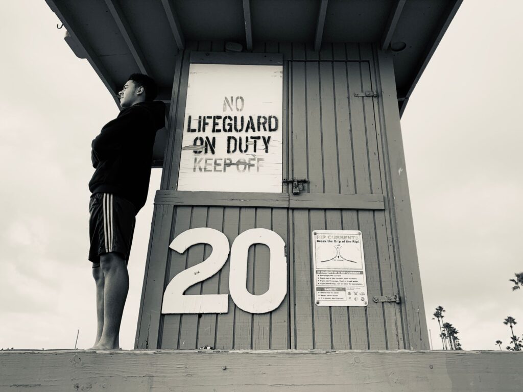 lifeguard posting shark warning at a popular California beach closed due to aggressive sharks