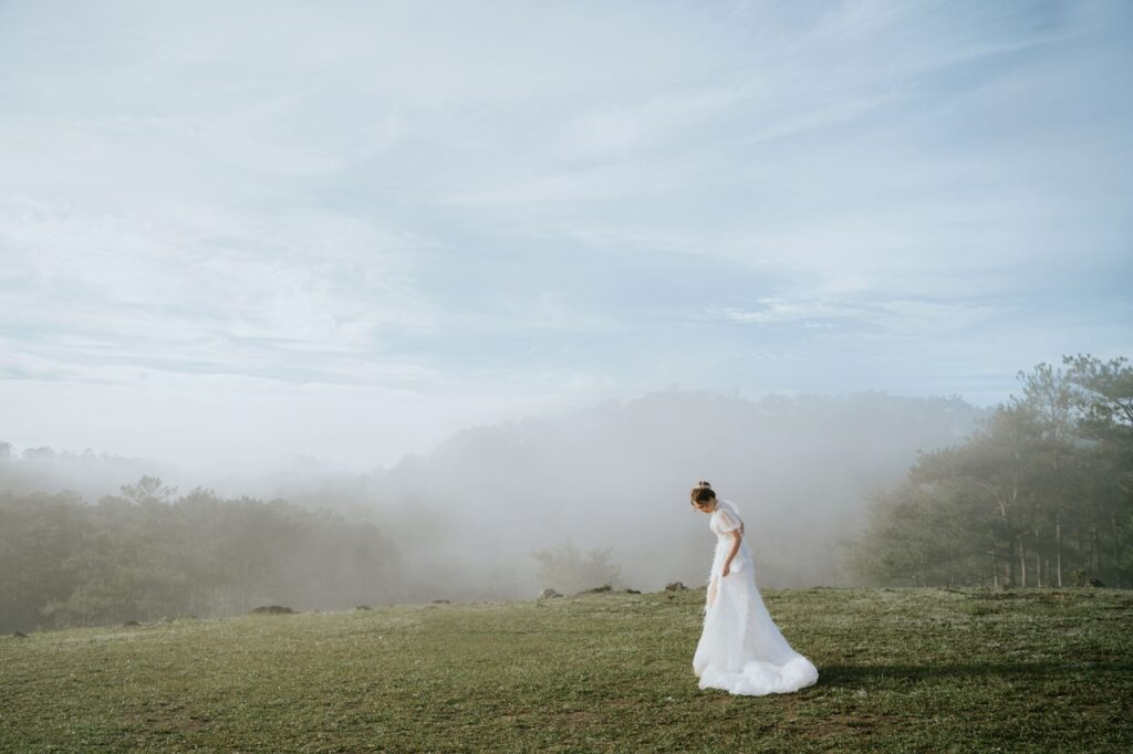 ghostly woman in white dress on dark road near cemetery