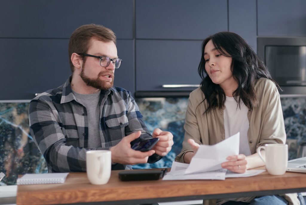 married couple under financial stress discussing paperwork