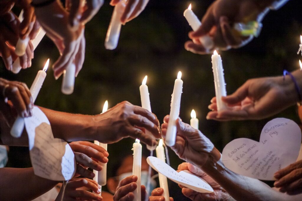 neighborhood residents holding candles at a community vigil after a fatal shooting in Kansas City