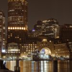 Boston's illuminated skyline over the harbor at night