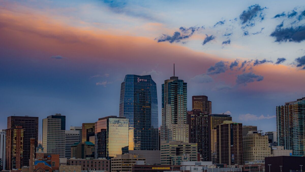 Downtown Denver skyline at sunset with colorful clouds above the skyscrapers