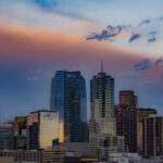 Downtown Denver skyline at sunset with colorful clouds above the skyscrapers