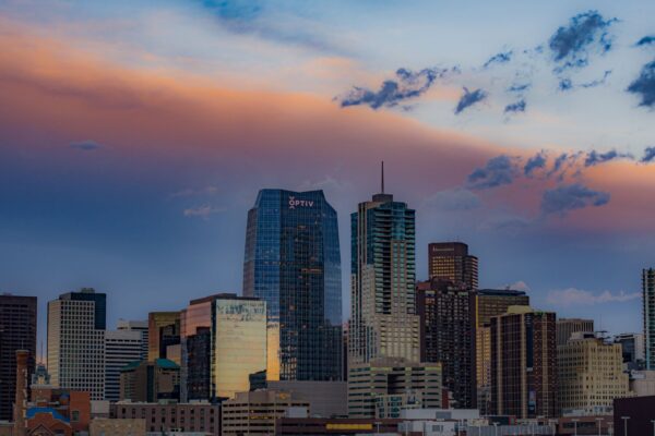 Downtown Denver skyline at sunset with colorful clouds above the skyscrapers