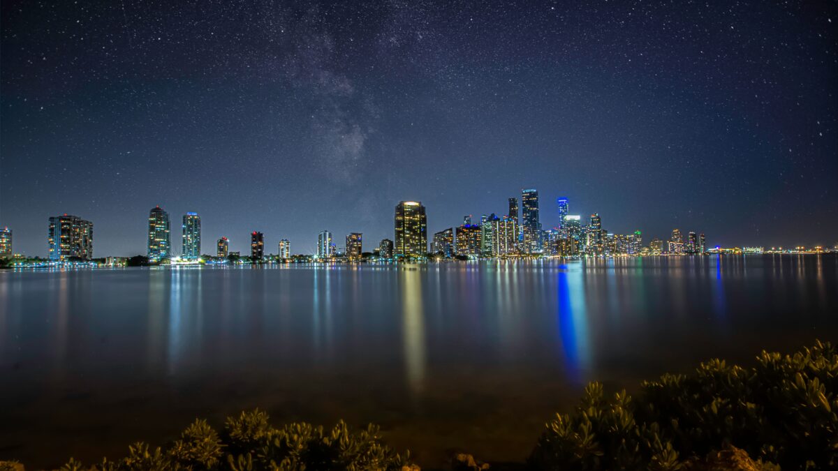 Downtown Miami skyline photographed at dusk with city lights reflecting on the water