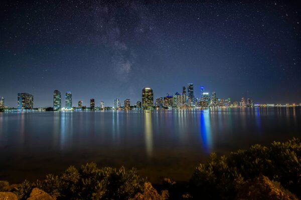 Downtown Miami skyline photographed at dusk with city lights reflecting on the water