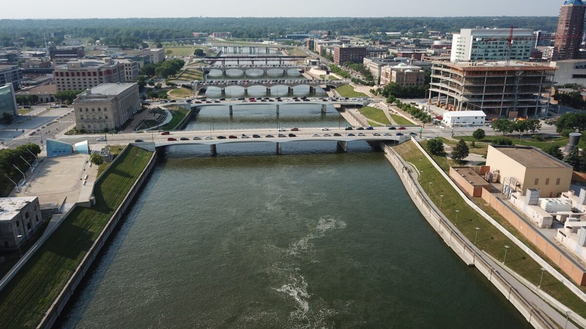 Aerial view of downtown Des Moines, Iowa, with the river and bridges under a clear sky