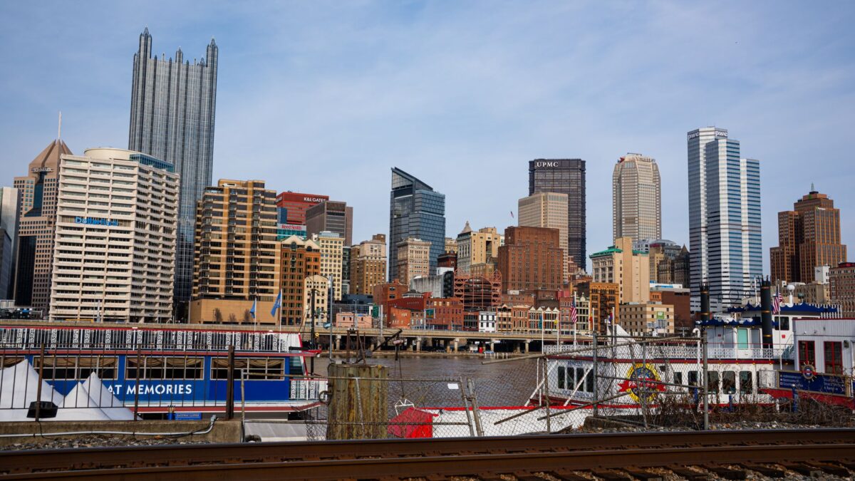 Pittsburgh skyline with skyscrapers and a riverboat along the waterfront