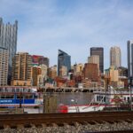 Pittsburgh skyline with skyscrapers and a riverboat along the waterfront