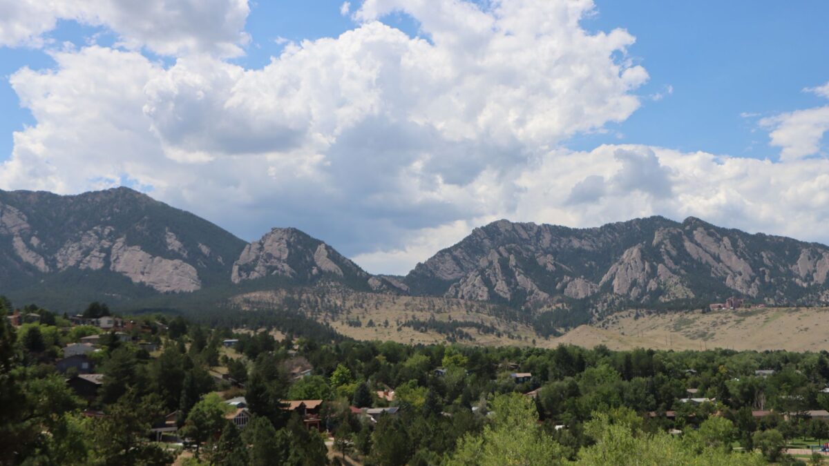 Snow-dusted Flatirons rising above Boulder, Colorado under a blue sky