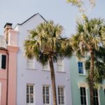 Pastel historic homes and palm trees on a sunny street in Charleston, South Carolina