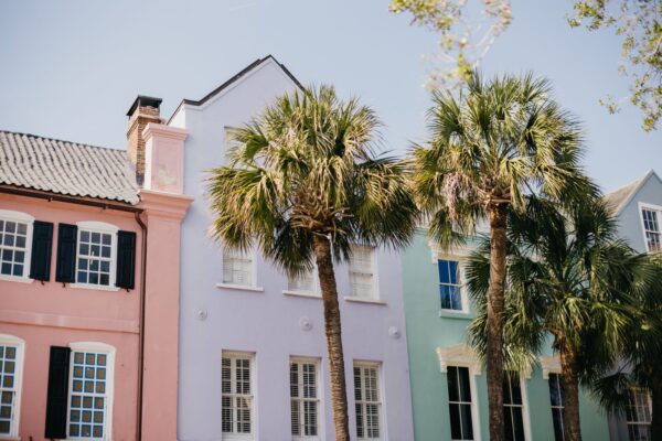 Pastel historic homes and palm trees on a sunny street in Charleston, South Carolina