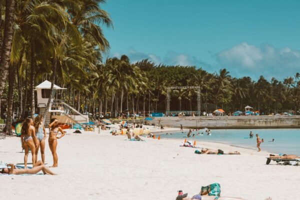 Waikiki beach in Honolulu with palm trees, white sand, and swimmers in turquoise water